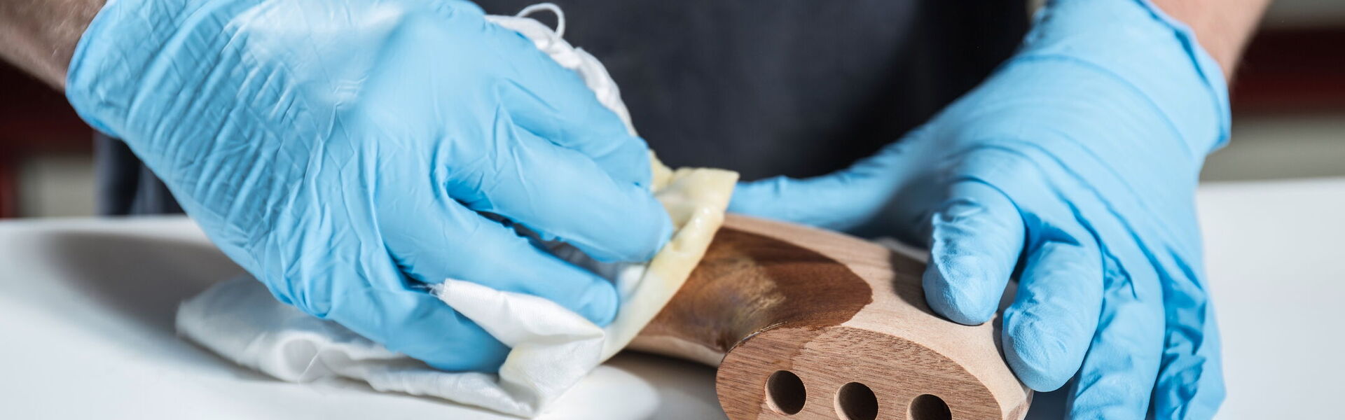 Ein Mann poliert ein Holzteil