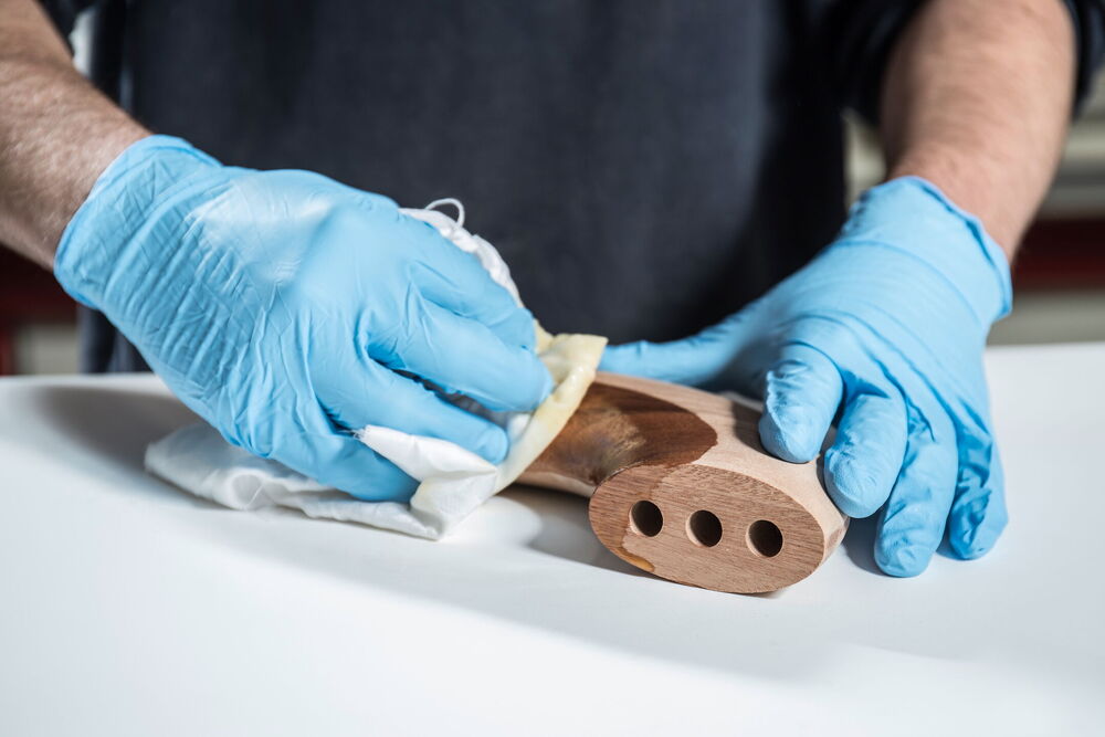 Ein Mann poliert ein Holzteil